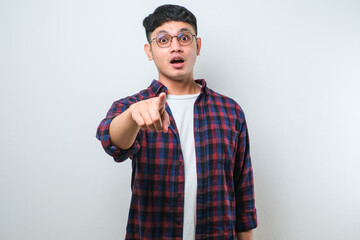Wall Mural - Asian young man in casual shirt pointing forward, Looking at Camera, make choosing you gesture