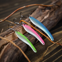 Three Fishing Lures On Wooden Desk