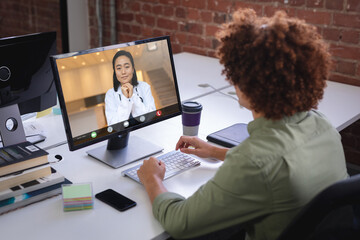 Poster - Biracial businessman attending meeting with asian woman through desktop pc in office