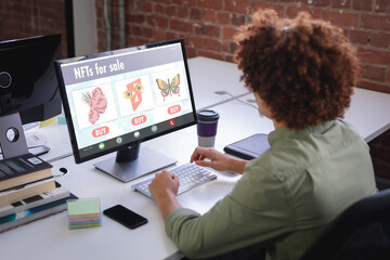Poster - Biracial businessman researching on nfts while working on desktop pc in office