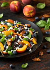 Wall Mural - Peach, blueberry salad with vegetables, feta cheese and pecan nuts. Healthy summer food