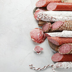 Wall Mural - Sausages salami assortment on light background.