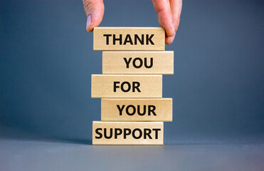 Thank you for support symbol. Concept words Thank you for your support on wooden blocks on a beautiful grey table grey background. Businessman hand. Business and thank you for support concept.