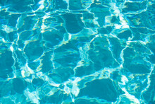 Background Of Blue Water In Swimming Pool With Sun Reflection, Ripple Water Wave In Pool. Clear Water Background.