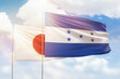 Sunny blue sky and flags of honduras and japan