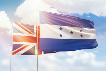 Sunny blue sky and flags of honduras and united kingdom