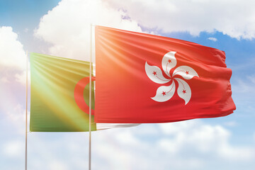 Sunny blue sky and flags of hong kong and algeria