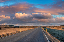 Diminishing Road Amidst Volcanic Landscape. Empty Highway Against Dramatic Sky During Sunset. Scenic View Of Street In Northern Alpine Region During Stormy Weather.