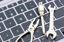 Computer Hardware Service And Maintenance Concept : Open-end Wrench, A Screwdriver, A Needle-nose Plier On A Computer Keyboard, Depicts Repairing, Software Updating Or Changing To A Newer Version.