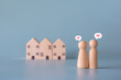 Small wooden faceless figures of human family members with heart icon and house. Property, hospitality, orphanage concept using wooden house and human model.