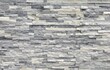 Stone cladding wall made of regular  bricks of white, gray and black rocks. Panels for exterior, background and texture.	