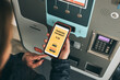 © Przemek Klos - Woman paying for parking ticket at car parking payment machine using mobile app on smartphone. Car parking application on mobile phone