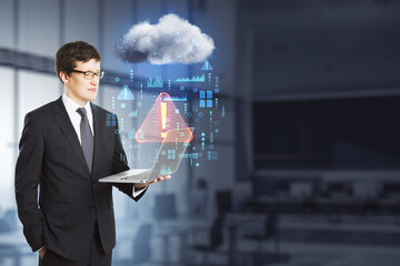 Poster - businessman with laptop standing in blurry office interior with abstract hologram raining cloud and mock up place. Data, information leak, security and theft concept. Double exposure.