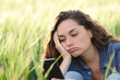 © Antonioguillem - Bored woman checking phone in a wheat field