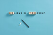 The motivational message believe in yourself with wooden cubes. Self confidence, courage, encouragement and personal trust