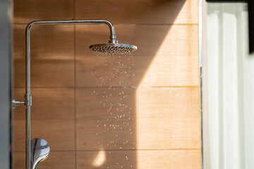 Outdoor shower head for the bath and showering cold water to body before jumping in the resort pool.