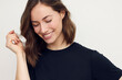 © Martin Villadsen - Portrait of beautiful brunette woman, smiling and looking down with white teeth. Close-up portrait of cute female girl in black t-shirt isolated on white background.