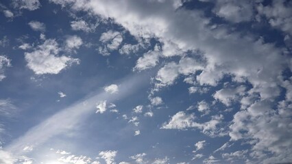 Wall Mural - 4k video time lapse of amazing cloudy sunny blue sky. sunrays, white fluffy clouds flying high overh