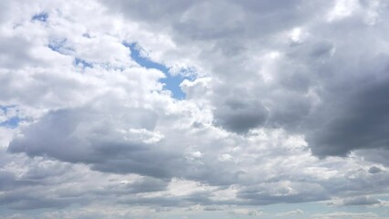 Wall Mural - 4k video time lapse of beautiful sunny cloudy sky. white and grey huge fluffy clouds flying in clear