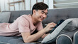 © paulaphoto - Portrait of asian handsome teenage man live online vlog  virtual computer at home sofa living room.Online sme marketing young happy man video call meeting on laptop alone at home. Communicate digital.
