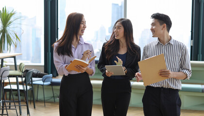 Wall Mural - Collaborative process of young asian business people team working together discussing, researching, brainstorming and planning work at business meeting in modern office building and city background