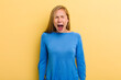 young adult blonde pretty woman shouting aggressively, looking very angry, frustrated, outraged or annoyed, screaming no