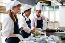 Group Of Student Girl Learning. Cooking Class. Culinary Classroom. Group Of Happy Young Woman Multi - Ethnic Students Are Focusing On Cooking Lessons In A Cooking School.
