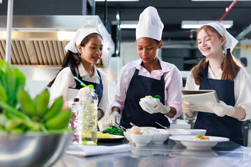 take note on book. Cooking class. culinary classroom. group of happy young woman multi-ethnic students are focusing on cooking lessons in a cooking school.