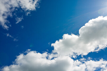 Wall Mural - Sunny background with blue sky and white clouds as summer natural background.