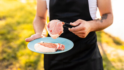 Wall Mural - Crop male chef with raw meat on plate