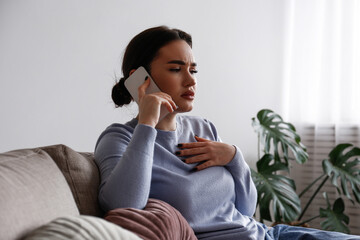 Portrait of upset young woman on the phone with a doctor receiving bad news. Sad female frowning, about to cry. Copy space for text, white wall background, close up.