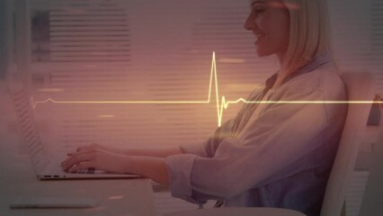 Canvas Print - Animation of cardiograph over caucasian businesswoman using laptop