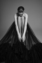 Beautiful Woman Pose In Studio. Art Portrait Of A Model In A Black Dress