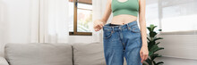 Healthy And Weight Loss Concept, Young Asian Woman In Loose Jeans When Success With Losing Weight