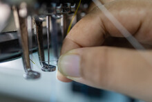 Worker Hand Putting Thread On Embroidery Needle In Textile Industry At Garment Manufacturers, Embroidery Needle, Needle With Thread (selective Focus And Soft Focus)