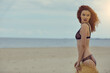 Beautiful redhead woman at a beach smiling