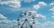 Small Ferris Wheel Against A Perfect Blue Sky With White Clouds. Slow Rotation, Calm Rest