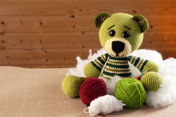 Wall Mural - Crochet from the yarn with amigurumi dolls. Background photo. Soft toy, knitting hook, balls of yarn.