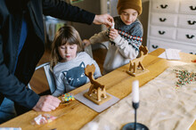 Parent Making Gingerbread Reindeer With Children Together