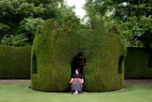 Woman Sitting In A Bush Cut Out As A Thrown In The English Countryside