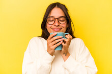 Young Hispanic Woman Holding A Mug Isolated On Yellow Background