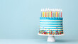 Striped buttercream birthday cake with colorful birthday candles and sprinkles