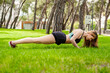 © platinumArt - Cute brunette woman wearing sports bra standing on city park, outdoors. Confident girl doing push up on grass. Healthy life outdoor sport concept.