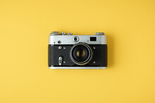 Old Retro Camera On The Yellow Background. Stylish Background For A Photo Enthusiast. Flat Lay