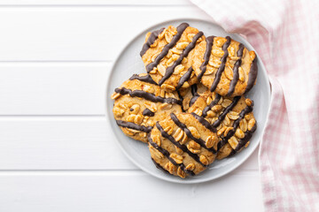 Wall Mural - Chip cookies with peanuts and chocolate strips on white table.