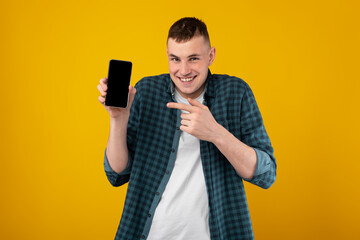 Poster - Funny Guy Showing Phone Pointing Finger At Screen, Yellow Background