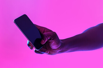 Poster - Unrecognizable black guy using cellphone with blank screen in neon light, free space for website or mobile app, mockup