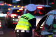 Policjantka kieruje ruchem drogowym wieczorem podczas szczytu w korkach ulicznych. 