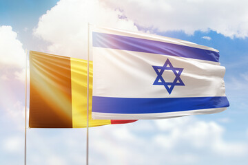 Sunny blue sky and flags of israel and belgium