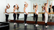 © JackF - Group of multiethnic dancers standing with one hand on barre and reaching over hand .in bright fitness room
